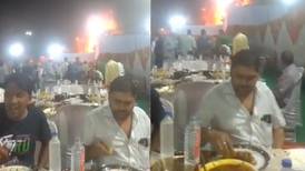 En plena boda en la India, dos hombres permanecen comiendo mientras se incendia una carpa