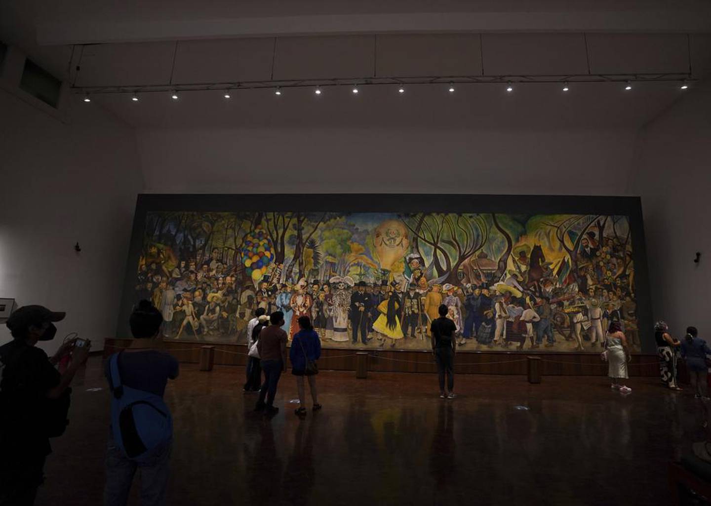 Visitantes observan el mural "Sueño de una tarde dominical en la Alameda Central" del artista mexicano Diego Rivera en el Museo Mural Diego Rivera, en Ciudad de México, el domingo 5 de junio de 2022. (Foto AP/Fernando Llano)