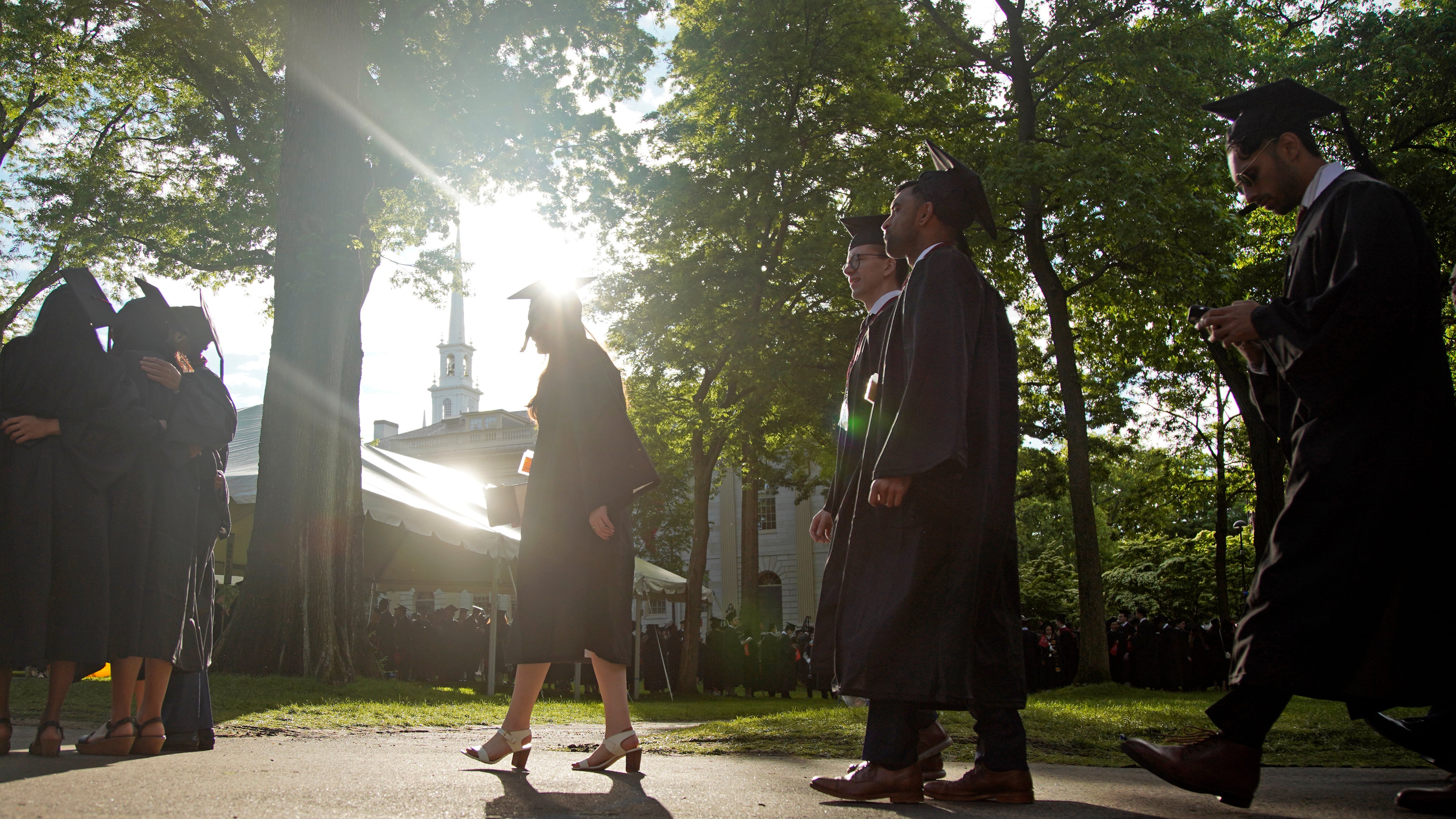 Graduados caminan hacia su ceremonia de fin de término en Harvard.