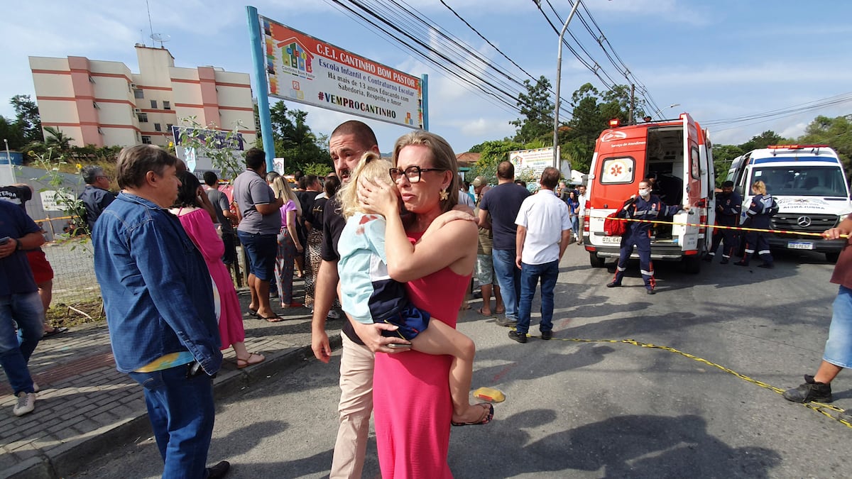 Una mujer reconforta a una niña que llora frente a la guardería Cantinho do Bom Pastor tras un ataque fatal a niños en Blumenau, estado de Santa Catarina, Brasil. (AP)